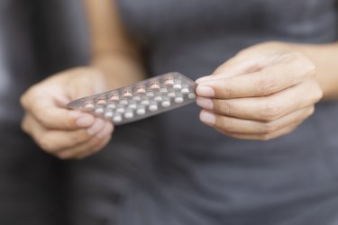 Midsection Of Woman Holding Blister Pack of birth control pills, as a cause of recurring yeast infections