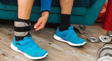 Close up of a man closing velcro strap of an ankle weight
