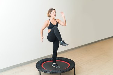 Woman doing a rebounder workout on a mini trampoline