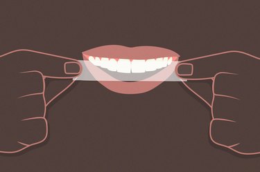 An illustration of a person applying a whitening strip on their teeth