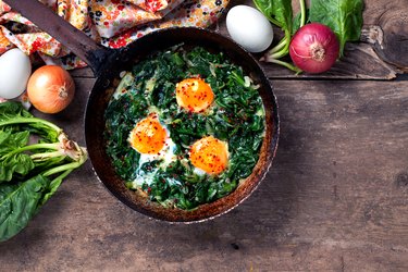Braised spinach and eggs in an old frying pan with immune boosting foods